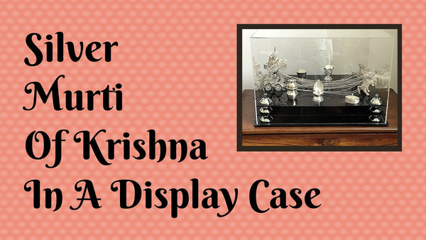 Silver Murti Of Krishna In A Display Case