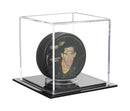 Clear acrylic hockey puck display case with black base for collectible hockey memorabilia