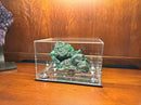 Malachite specimen displayed in a clear acrylic display case