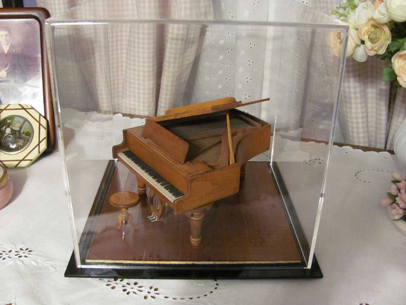 Tiny model piano in display case