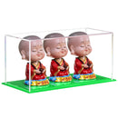 Clear acrylic display case with green base for collectibles