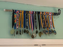 Clear acrylic bracket holding a standard size field hockey stick